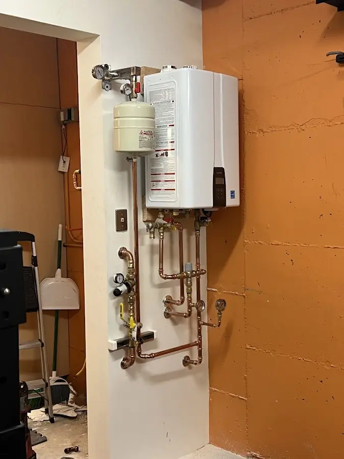 Plumbing technician inspecting water heater connections in Austell